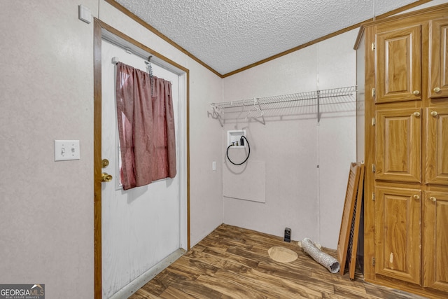 laundry area with hardwood / wood-style flooring, washer hookup, crown molding, and a textured ceiling