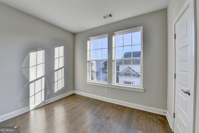 unfurnished room with dark hardwood / wood-style flooring