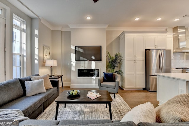 living room with crown molding and light wood-type flooring