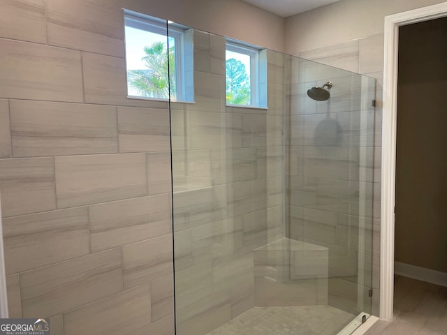 bathroom with hardwood / wood-style flooring and an enclosed shower