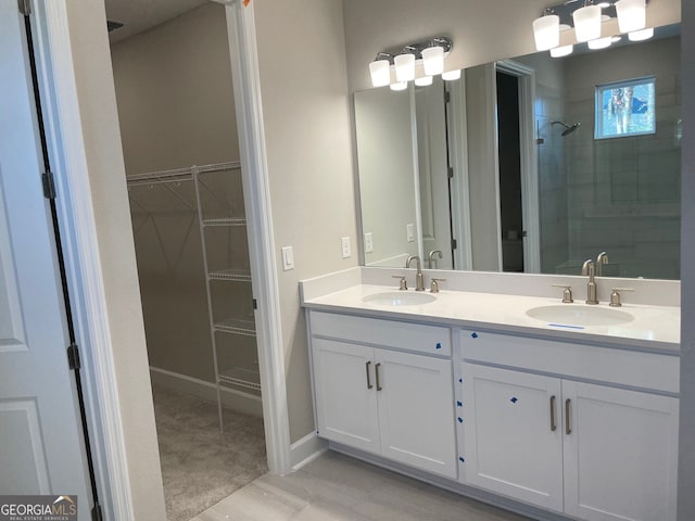 bathroom with tile patterned flooring, vanity, and walk in shower