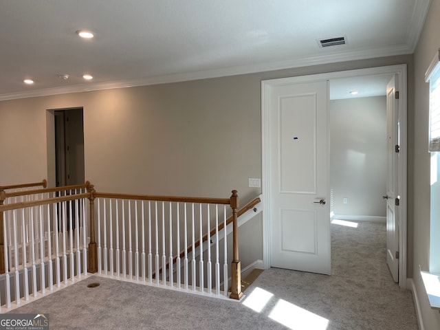 hall with crown molding and light carpet