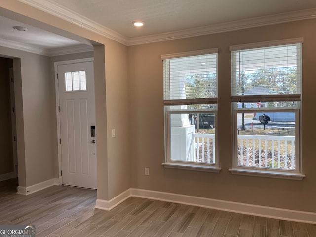 entryway with ornamental molding, plenty of natural light, and hardwood / wood-style floors