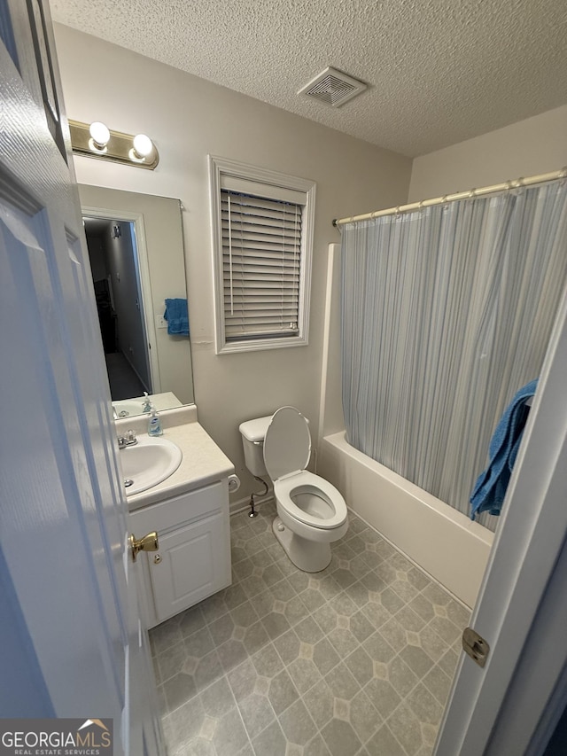 full bathroom featuring shower / tub combo, vanity, a textured ceiling, and toilet