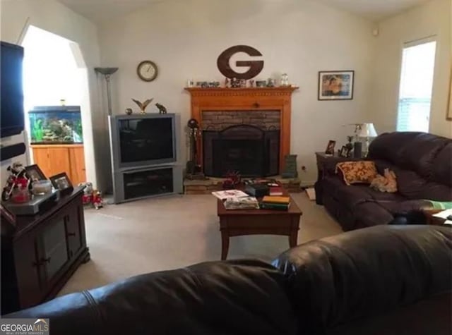 living room with a fireplace and light colored carpet