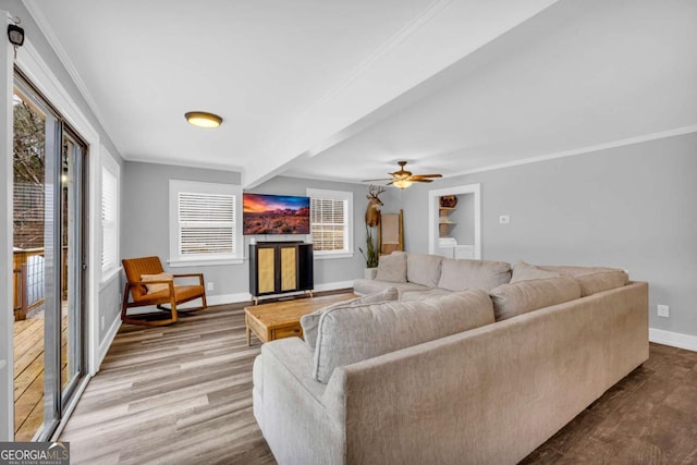 living room featuring hardwood / wood-style flooring, ornamental molding, and beamed ceiling