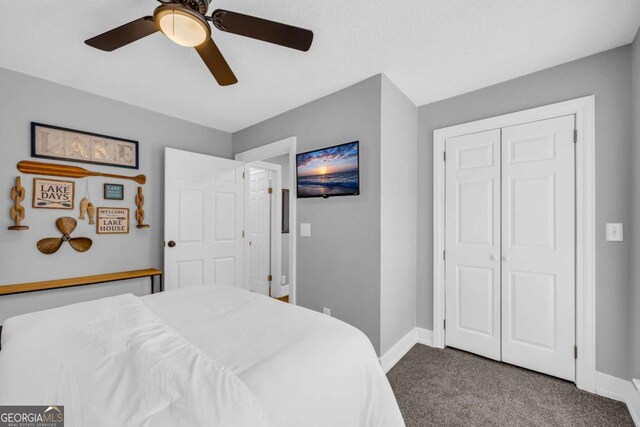 carpeted bedroom featuring ceiling fan and a closet