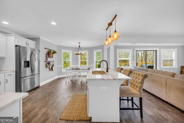 kitchen featuring white cabinetry, sink, a kitchen breakfast bar, and stainless steel fridge with ice dispenser