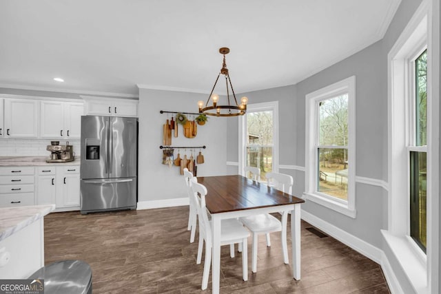 dining space featuring crown molding and an inviting chandelier