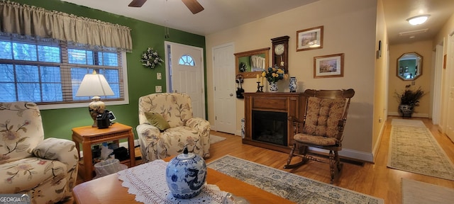 living area with light hardwood / wood-style flooring and ceiling fan