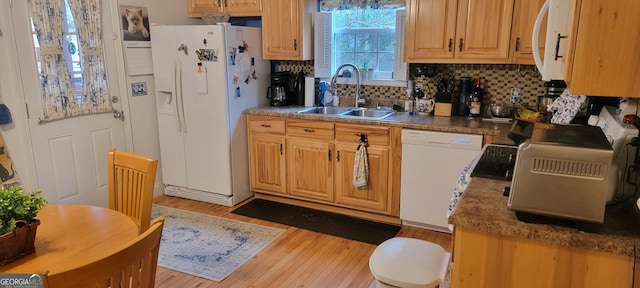 kitchen with white appliances, wood-type flooring, sink, and decorative backsplash