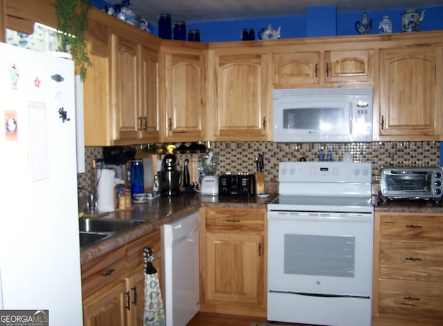 kitchen featuring backsplash, white appliances, and sink