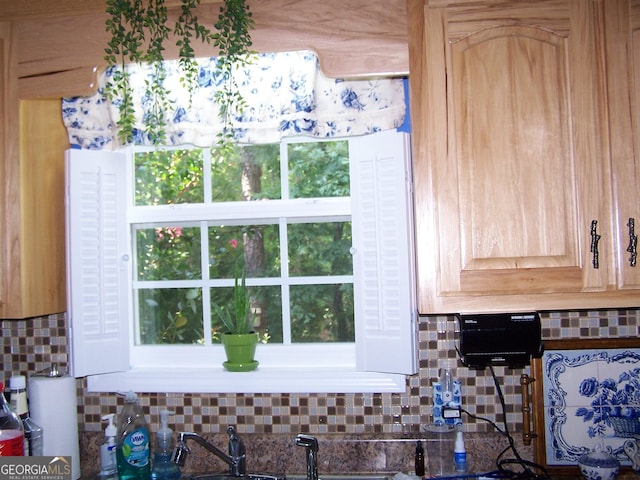 room details featuring light brown cabinets and decorative backsplash