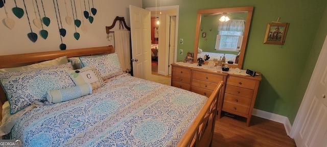 bedroom with dark hardwood / wood-style floors