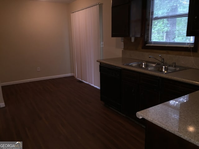 kitchen with dishwasher, light stone countertops, sink, and dark hardwood / wood-style floors