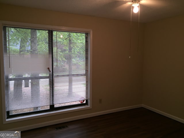 unfurnished room featuring dark hardwood / wood-style floors and a textured ceiling