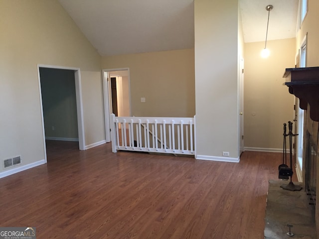 unfurnished living room with high vaulted ceiling and dark hardwood / wood-style flooring