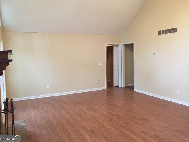 unfurnished room with lofted ceiling and dark hardwood / wood-style floors