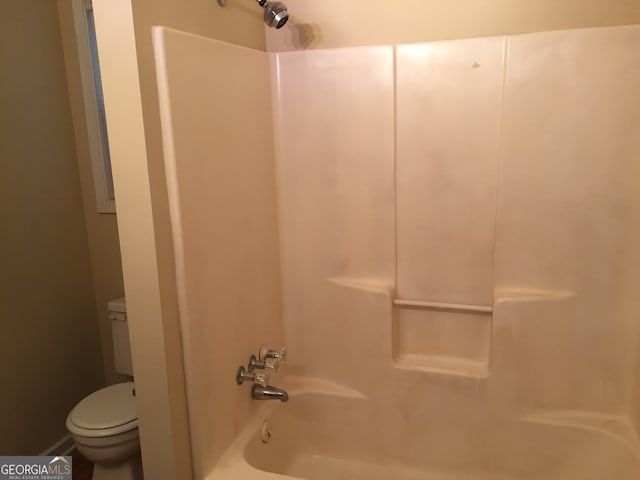 bathroom featuring tub / shower combination and toilet