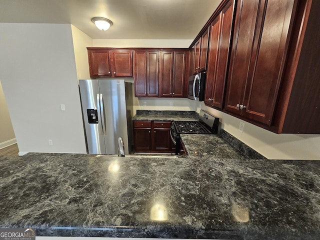 kitchen featuring dark stone countertops and stainless steel appliances