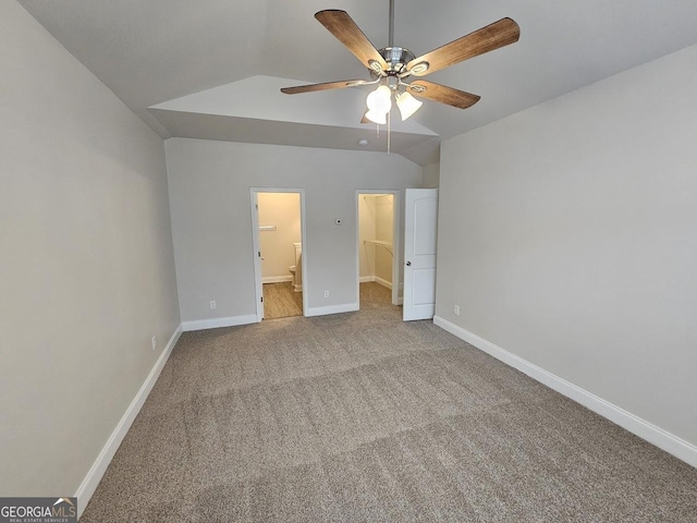 unfurnished bedroom with connected bathroom, vaulted ceiling, ceiling fan, and carpet flooring