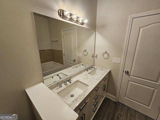 bathroom featuring vanity, hardwood / wood-style floors, and a tub to relax in