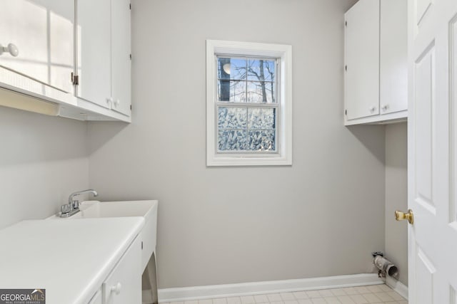 washroom with cabinet space and baseboards