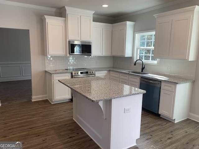 kitchen featuring stainless steel appliances, a center island, and white cabinets