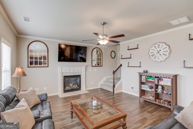 living room featuring hardwood / wood-style flooring, ornamental molding, and ceiling fan