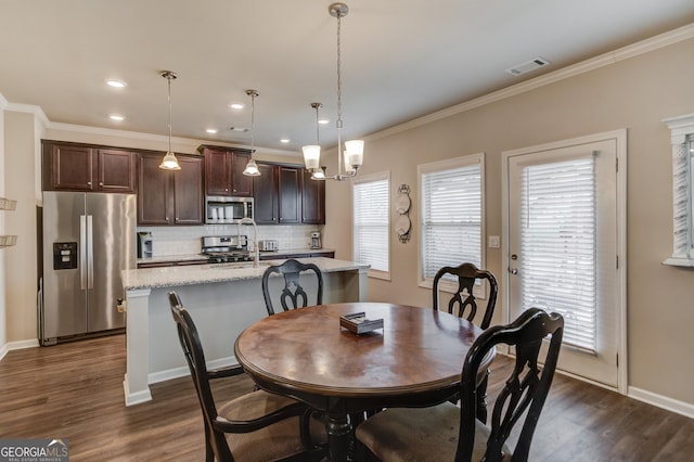 dining space featuring ornamental molding and dark hardwood / wood-style floors