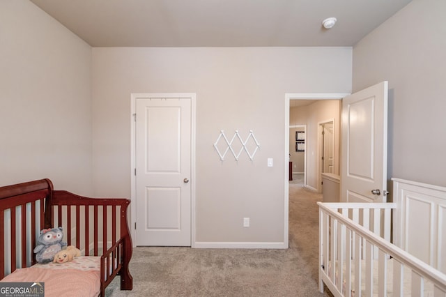 carpeted bedroom featuring a nursery area