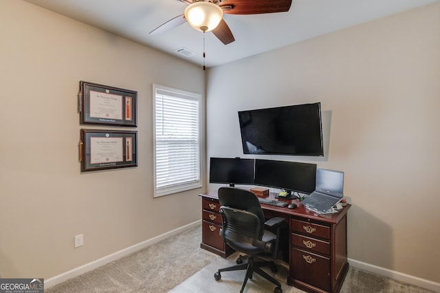 carpeted office space with ceiling fan