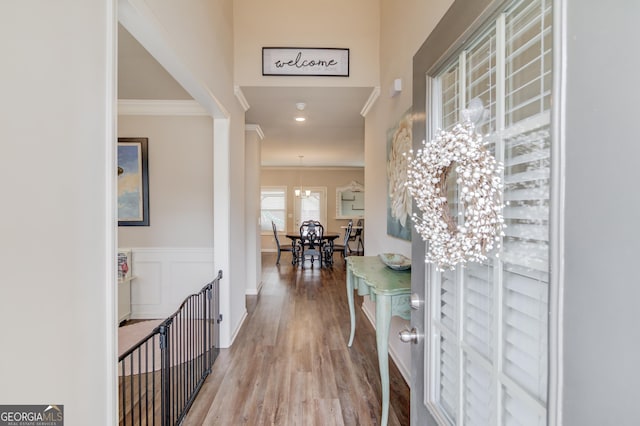 foyer featuring ornamental molding, a chandelier, and light hardwood / wood-style floors