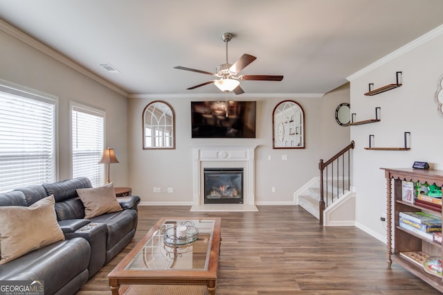 living room featuring wood-type flooring, ornamental molding, and ceiling fan