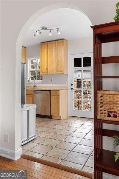 kitchen with appliances with stainless steel finishes, sink, and light brown cabinets