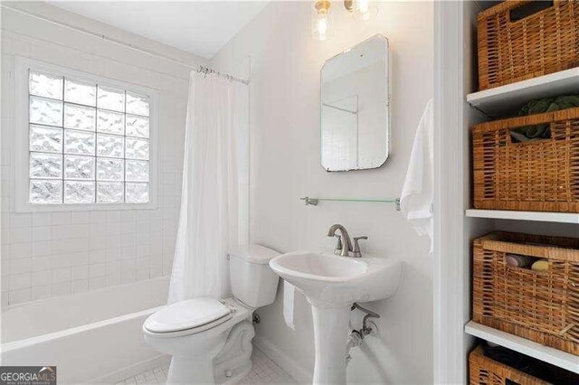 bathroom featuring shower / tub combo with curtain, tile patterned floors, and toilet