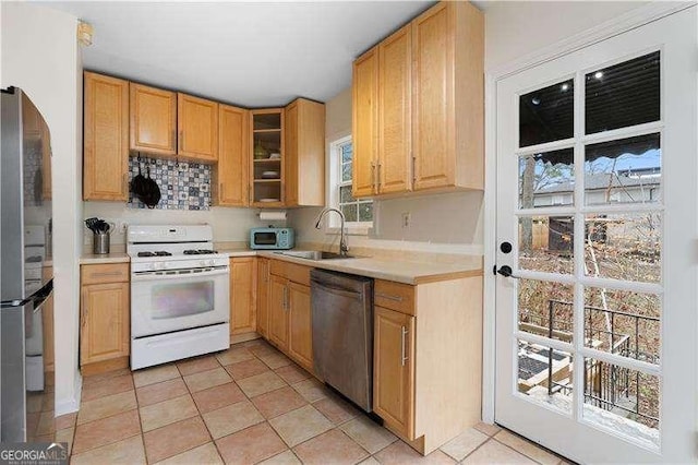 kitchen with light tile patterned flooring, appliances with stainless steel finishes, sink, and light brown cabinets