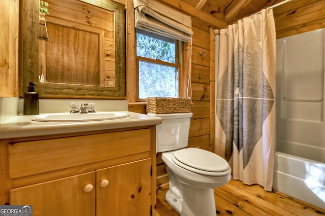 full bathroom featuring hardwood / wood-style floors, rustic walls, vanity, shower / tub combo, and toilet