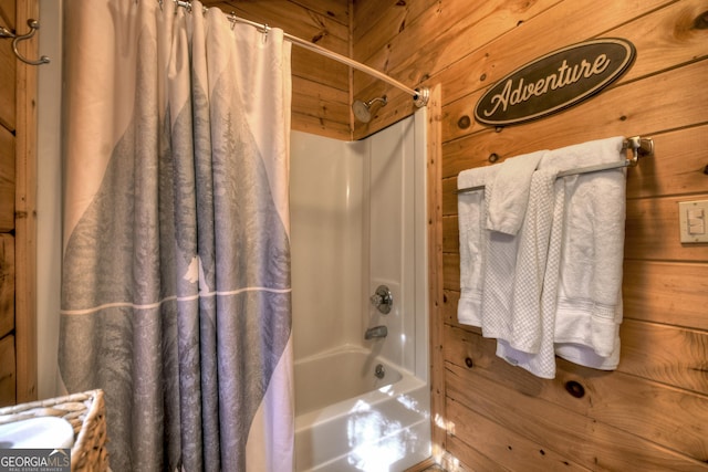 bathroom with shower / bathtub combination with curtain and wooden walls