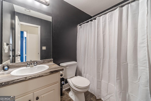 bathroom featuring vanity, hardwood / wood-style floors, a textured ceiling, and toilet