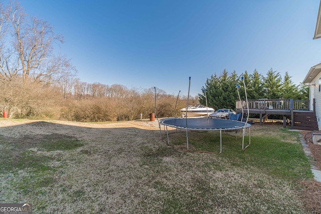 view of yard featuring a deck and a trampoline