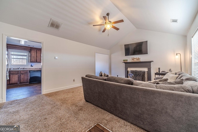 carpeted living room featuring sink, vaulted ceiling, and ceiling fan