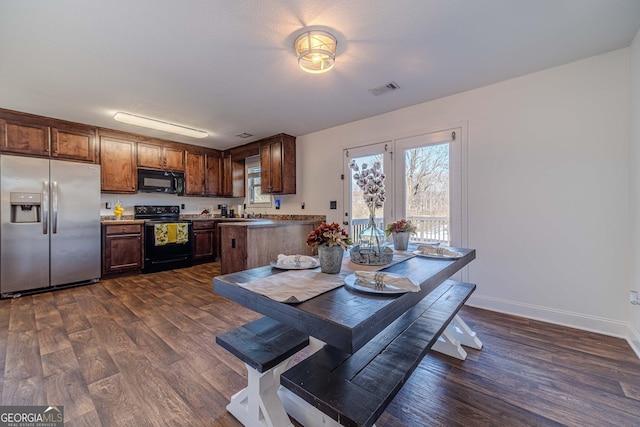 kitchen with sink, kitchen peninsula, dark hardwood / wood-style flooring, and black appliances