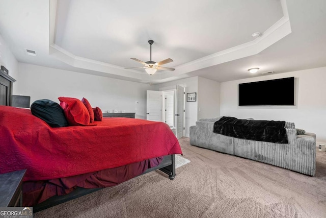 bedroom with a tray ceiling, carpet floors, and ceiling fan