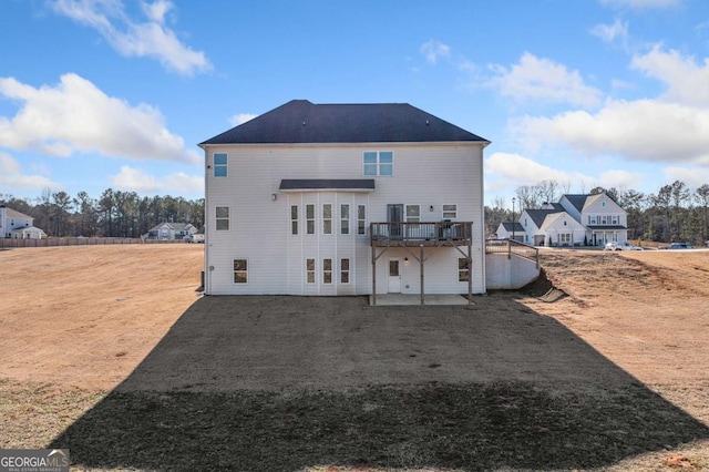 rear view of house with a wooden deck and a patio area