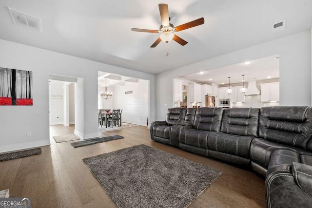 living room featuring hardwood / wood-style floors and ceiling fan with notable chandelier