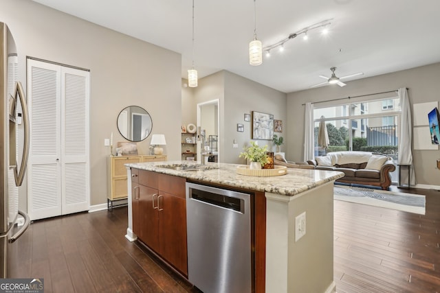 kitchen with stainless steel appliances, dark hardwood / wood-style floors, a kitchen island with sink, and hanging light fixtures