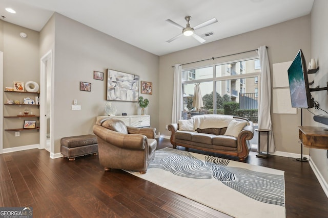 living room featuring dark wood-type flooring and ceiling fan