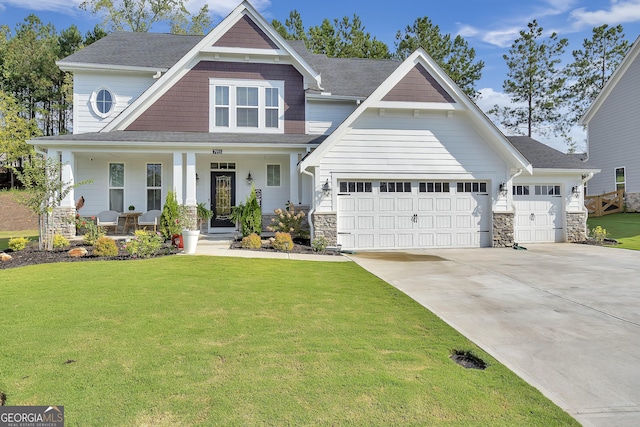 craftsman house with a garage, covered porch, and a front lawn