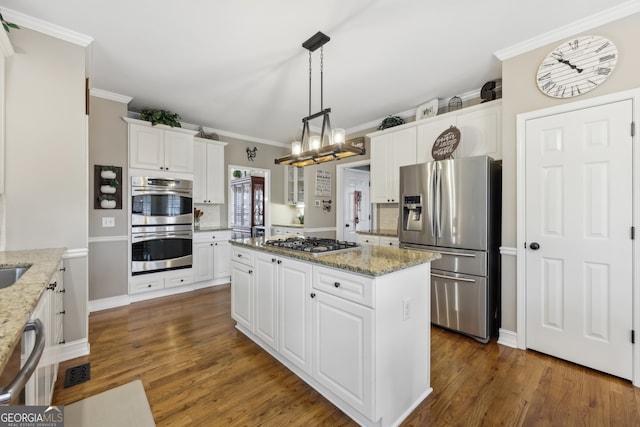 kitchen with white cabinetry, a center island, ornamental molding, stainless steel appliances, and light stone countertops